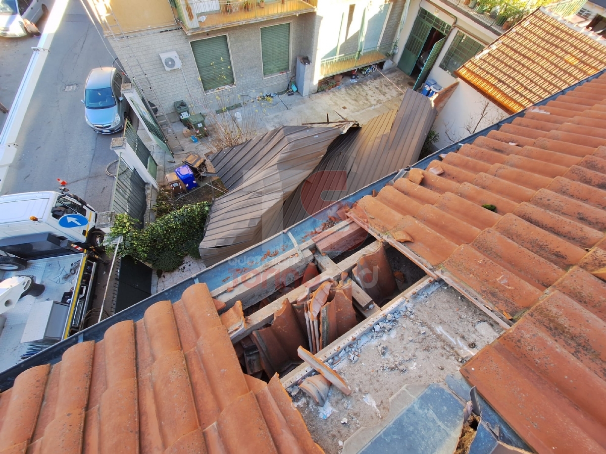 MONCALIERI - Tetto di un capannone sradicato dal vento finisce nel cortile di un palazzo