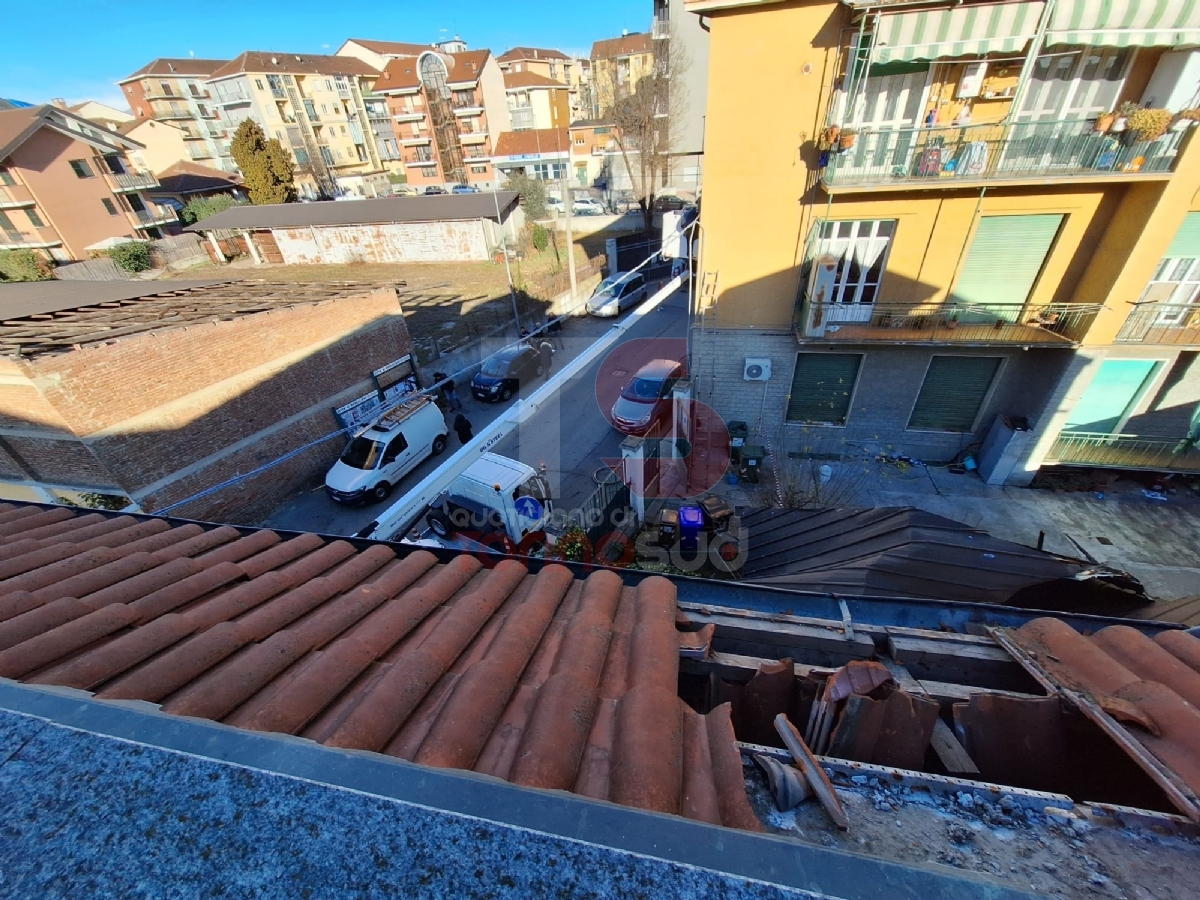 MONCALIERI - Tetto di un capannone sradicato dal vento finisce nel cortile di un palazzo